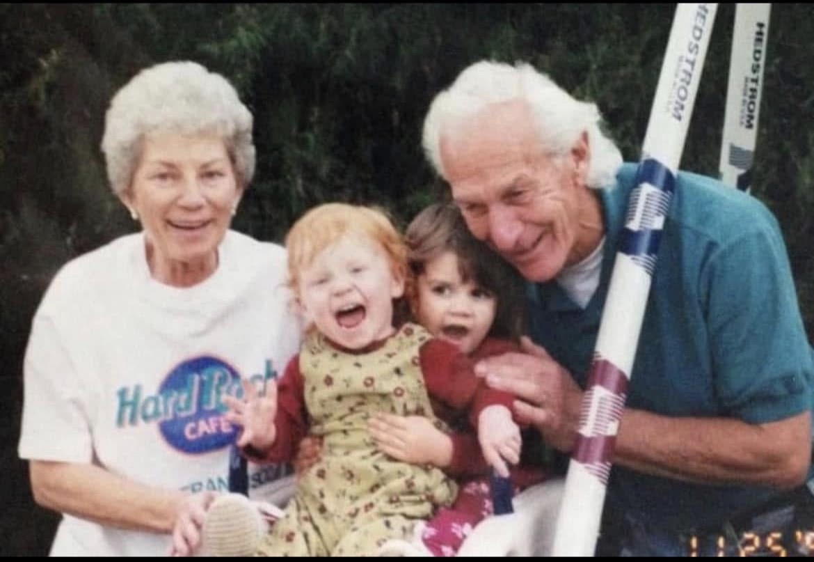 Grandparents laughing together with their two young grandchildren.